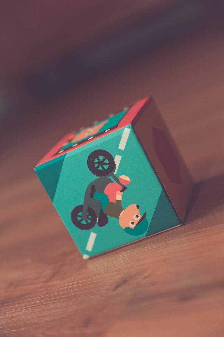 A close-up of a colorful toy cube on wooden floor, emphasizing play and childhood.